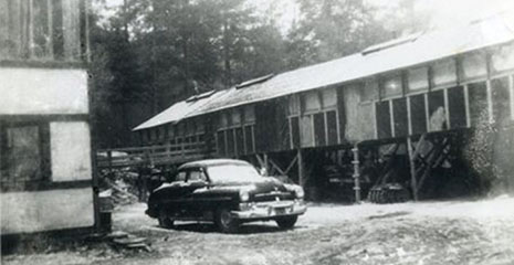 Ein Auto vor einer Community Playthings Werkstätte, etwa 1950