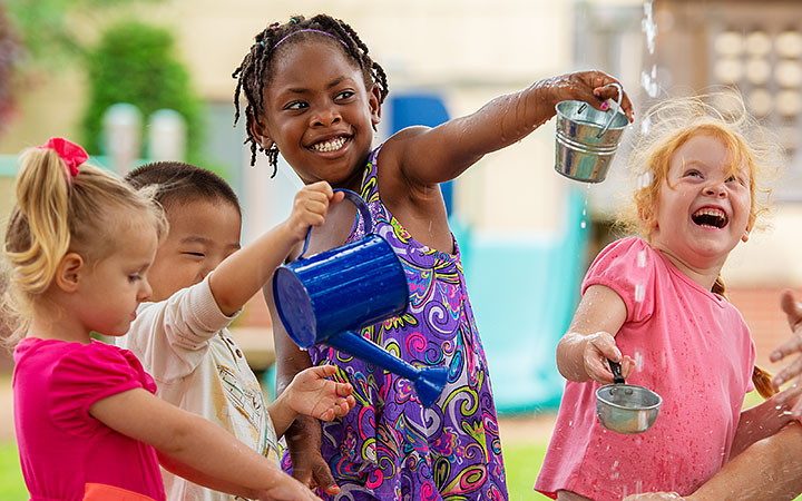 Eine Gruppe von Kindern, die lachen und mit Wasser spielen