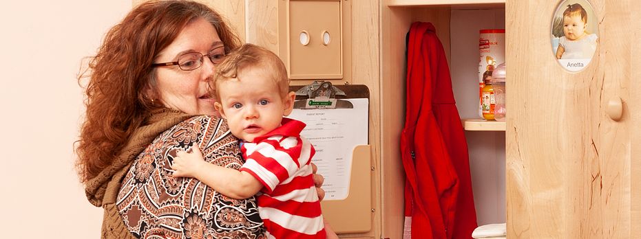 Erzieherin mit Kind auf dem Arm