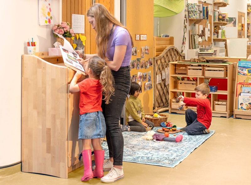 Kind mit Erzieherin am Stehpult