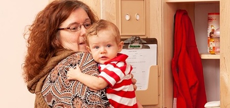 Erzieherin mit Kind auf dem Arm