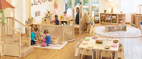 Eine Kindertagesstätte mit hellen Massivholzmöbeln und Raumteilern