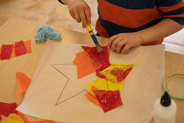 Die Hände eines Jungen über dem Bastelprojekt