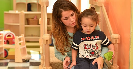 Eine Erzieherin spricht mit einem kleinen Kind