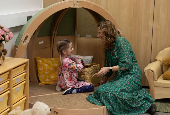 Ein Kind ko-reguliert mit einer Erzieherin