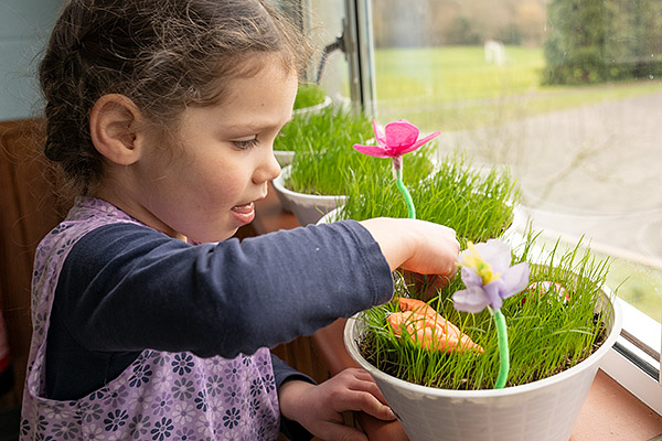 Mädchen dekoriert Gras im Korb