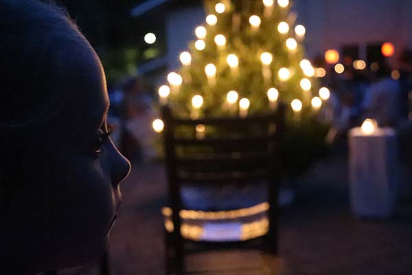 Durch Kerzen beleuchteter Baum mit Kindergesicht
