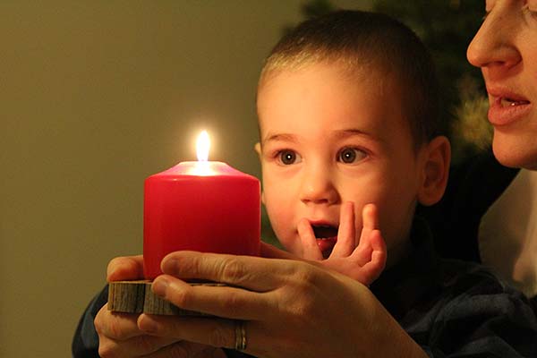Kind und Mutter mit roter Kerze