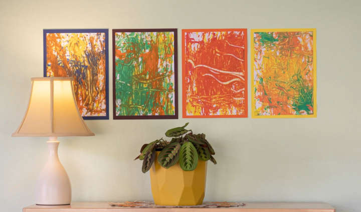 Vier Eichelbilder, schön an einer Wand hinter einer Lampe und einer Topfpflanze angeordnet