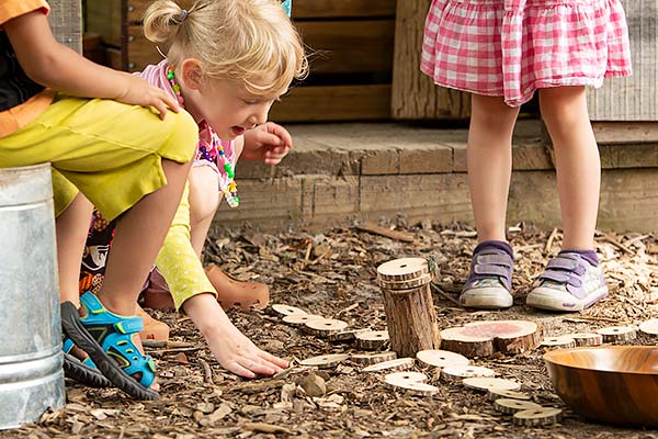 Kinder legen Muster mit Astscheiben