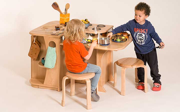 Zwei Kinder spielen an der hohen Kücheninsel