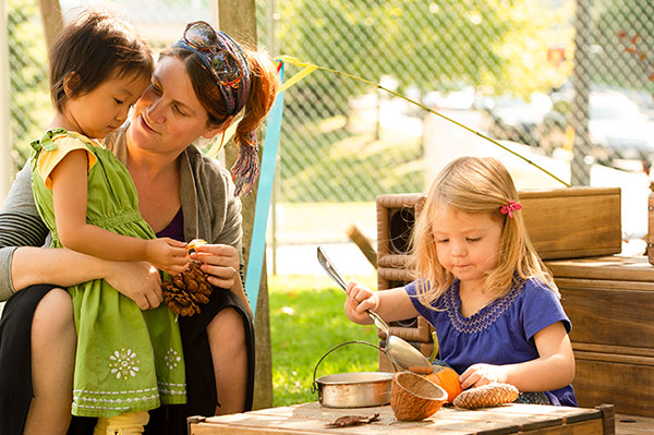 Eine Erzieherin spricht mit zwei Kindern