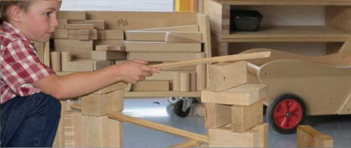 Ein sechsjähriger Junge experimentiert mit Kugelbahnen und Einheitsbausteinen