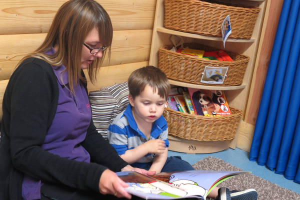 Eine Erzieherin liest einem Kind aus einem Bilderbuch vor