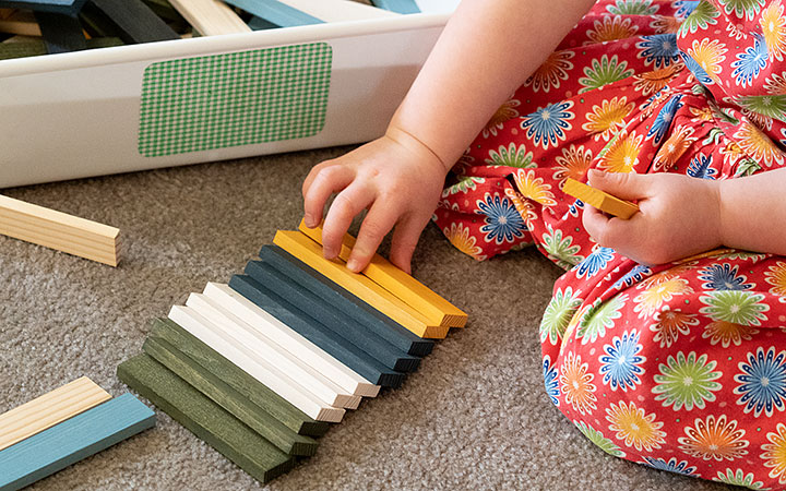 Ein Kind sortiert Bausteine nach Farben