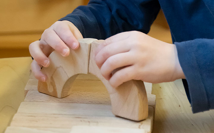 Toddler playing with small wooden blocks