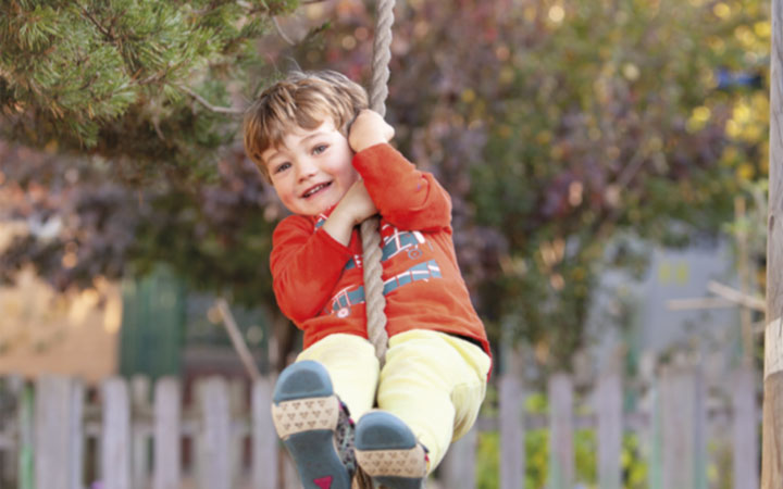 A happy boy on a rope swing