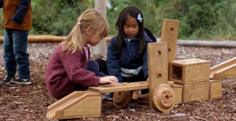 Zwei Mädchen spielen draußen mit Outlast Bausteinen