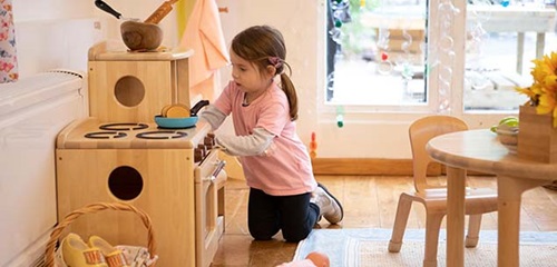 Girl playing with play collection stove