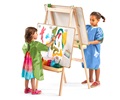 children wearing aprons painting pictures on an easel