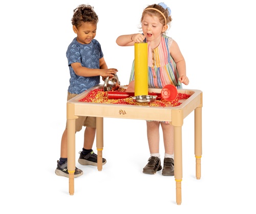 Ein Mädchen und ein Junge spielen mit sensorischen Materialien auf dem Sinnestisch.
