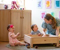 Babies playing in front of a lockable shelf