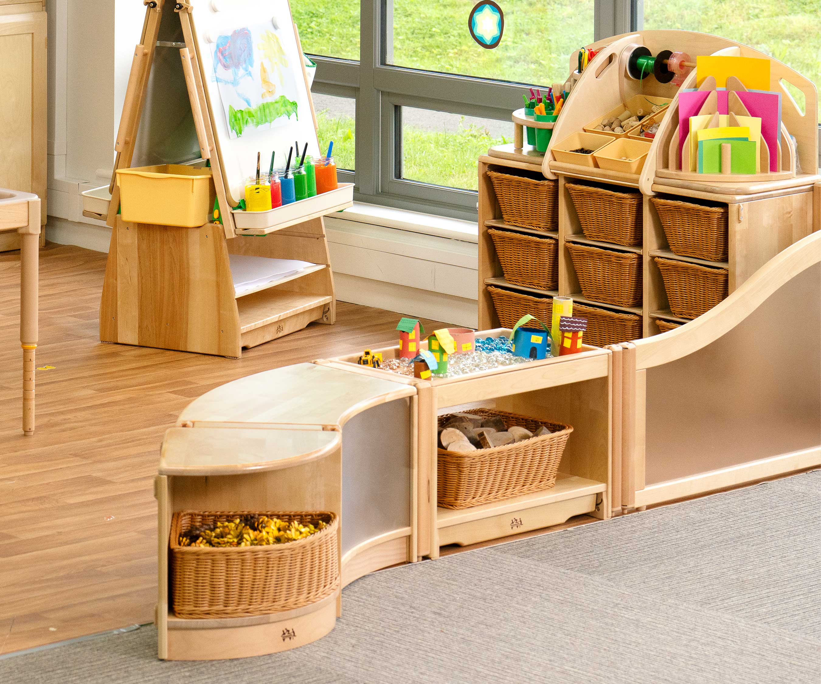 A classroom layout with solid wood furniture and resources in baskets