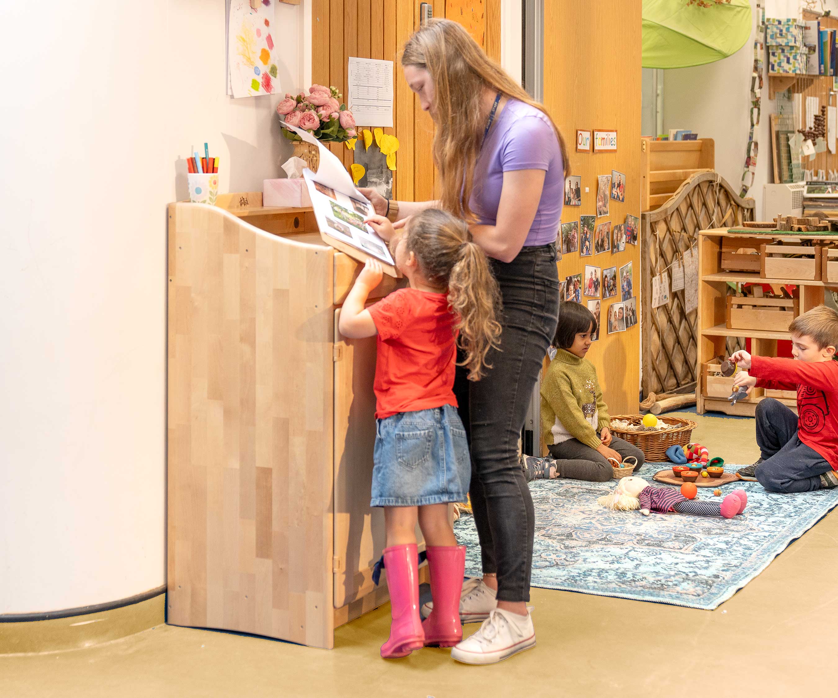 Erzieherin und Kind an einem Stehpult