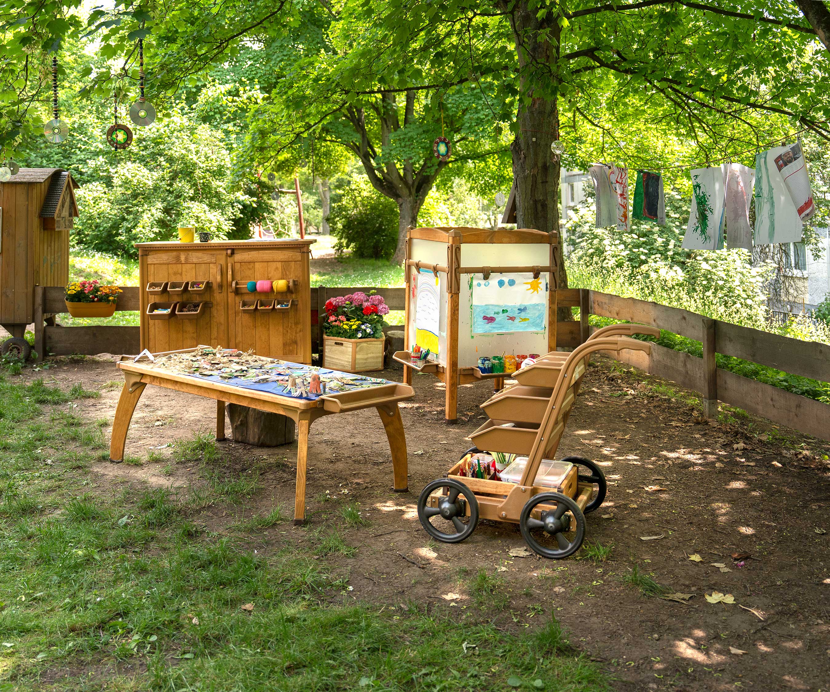 Ein Außenlernraum mit Staffelei, Kunstlagerhaus, Tisch und Versorgungstrolley.