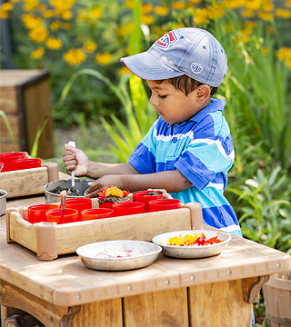 Young child playing with a mud kitchen