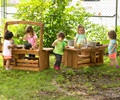 Children play with natural materials in an outdoor play area created with a toddler mud kitchen sink and counter.