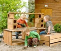 Three toddlers playing in a sandpit with the Outlast storage bench