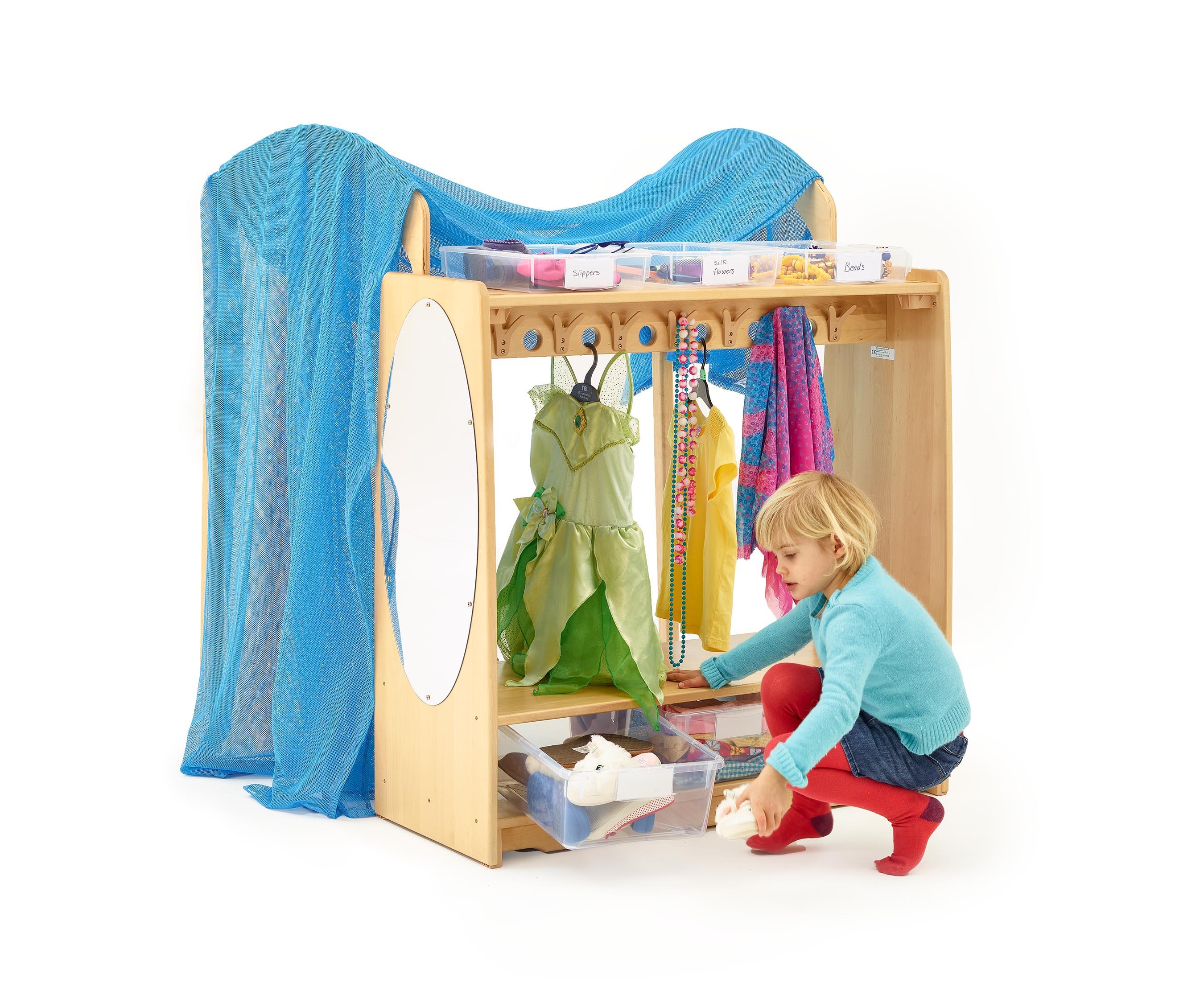 Ein Kind wählt Verkleidungsschuhe aus dem Drama Centre und Dress Up Schrank, der Kostüme und Accessoires enthält.