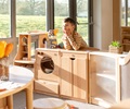 Play kitchen made from solid wood with a boy leaning over the counter