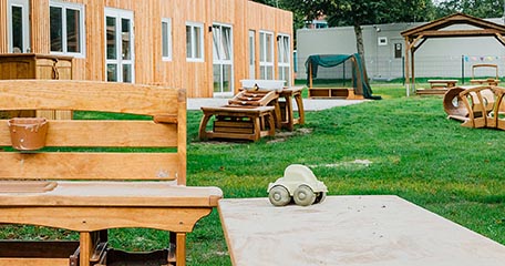 Ein Außenbereich mit wetterfesten Spielgeräten für draußen, darunter eine Matschküche und eine Kaskade.