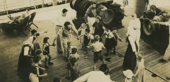 Erwachsene und Kinder spielen auf den Deck eines Schiffes, das 1940 den Atlantik überquert